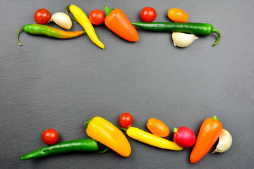 Gemüse auf einer Schieferplatte - Hintergrund für vegane und vegetarische Speisekarten mit Textfreiraum