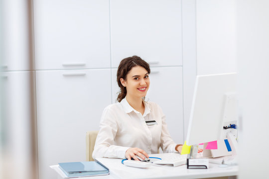 Friendly Woman Behind Reception Desk Administrator