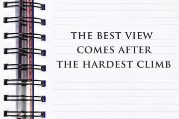 Inspirational motivating quote on spring white note book. the best view comes after the hardest climb.