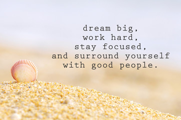 Inspirational motivating quote of shell clam on the sand at the beach. Dream big, work hard, stay focused, and surround yourself with good people. - 129757658