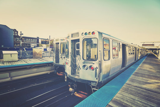 Retro stylized photo of a train on platform in Chicago, USA.