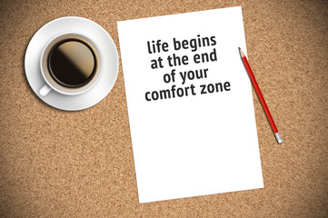 Inspirational motivating quote on paper with coffee, pencil and cork background. life begins at the end of your comfort zone