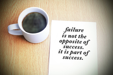Inspirational motivating quote on paper with black coffee on the table. Failure is not the opposite...