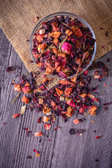 Dry tea in plate on rustic background