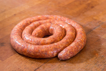 Rolled raw red sausage on the table