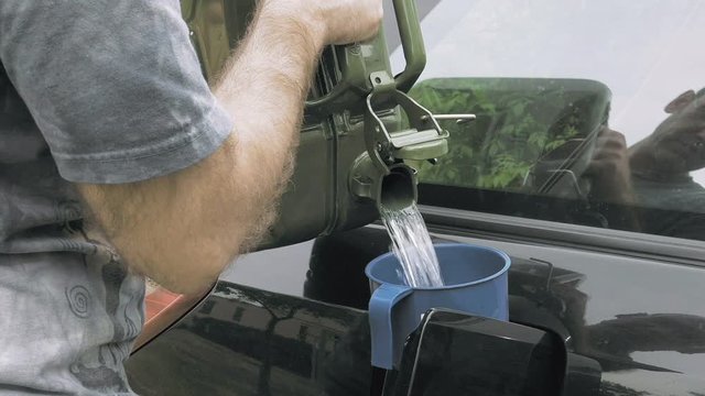 Man Fuels A Car From Jerry Can With Petrol Gas Or Diesel.