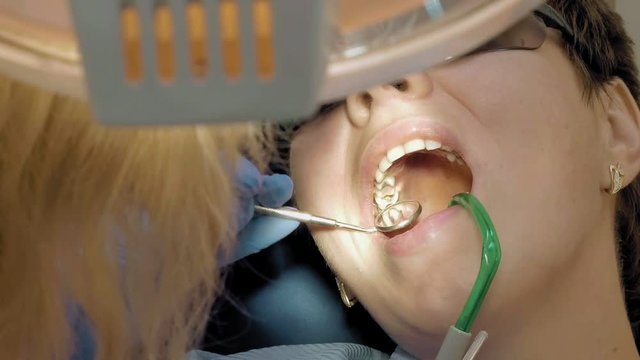 Woman at the dentist chair gets dental medical examination and treatment. POV low view shot. Odontic and mouth health is important part of modern human life that dentistry help with.