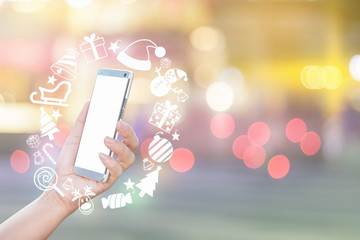 Woman's hand using smartphone and Christmas icon, sending Merry Christmas message via smartphone.