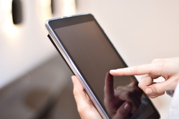 Businesswoman with notebook close-up. Finger touch tablet.