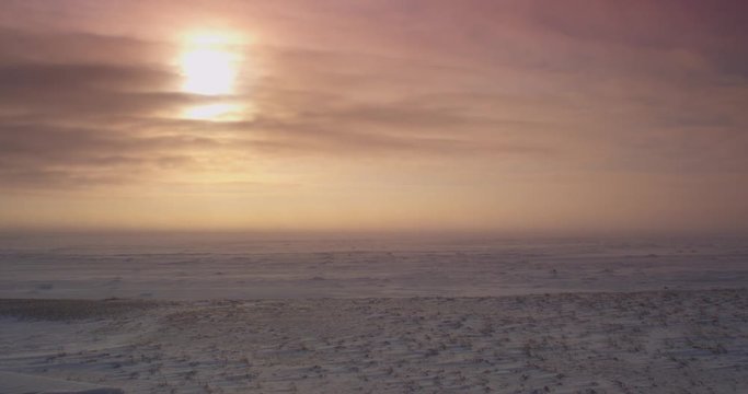 Waves of blizzard snow and clouds pass over tundra in storm