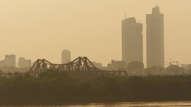 Hanoi city in the evening haze with railway bridge. Overlooking the river. Vietnam.
