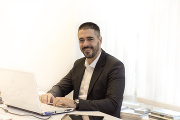 Businessman sitting at desk with a laptop working on. Business and office concept.