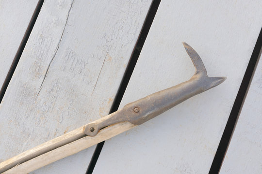 Boathook against white wooden planks
