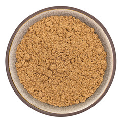 Organic coriander powder in ceramic bowl isolated on white background, top view