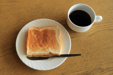 Diet set, plate of one toast with a cup of black coffee on woode