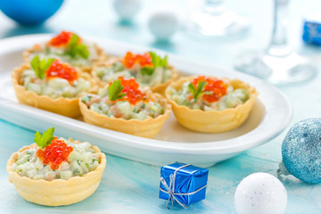 Festive Christmas appetizer tartlets stuffed with salmon salad