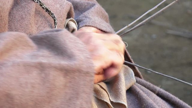 a man is weaving a wicker or gorse basket