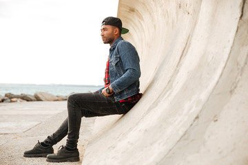 African man wearing cap walking on the beach