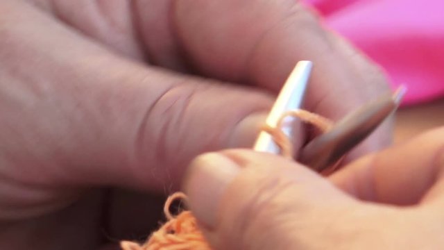 closeup footage on hands of a woman knitting