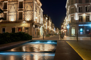 Fototapeta na wymiar Night view of the fountain and street in the center of Troyes in France.