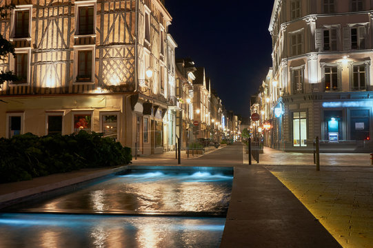 Night view of the fountain and street in the center of Troyes in France.