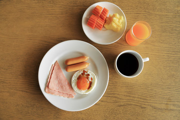 Fototapeta na wymiar Set of american breakfast on table, fried egg, ham, and sausage