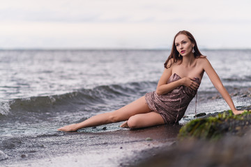 Fototapeta na wymiar Beautiful woman in a dress on a beach.