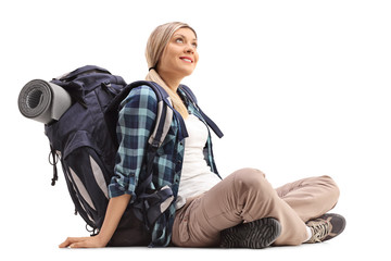 Female hiker sitting on the ground and looking up