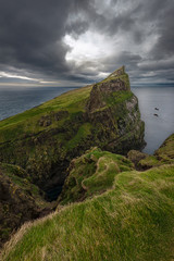 View over the northern tip of the island of Mykines with it's white lighthouse in the distance, Faroe Islands