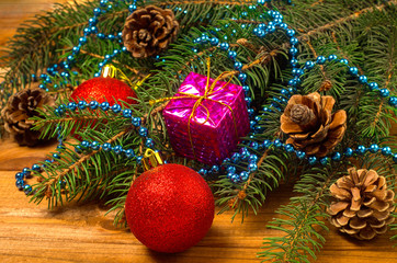 New Year's toys and spruce branches on a wooden background