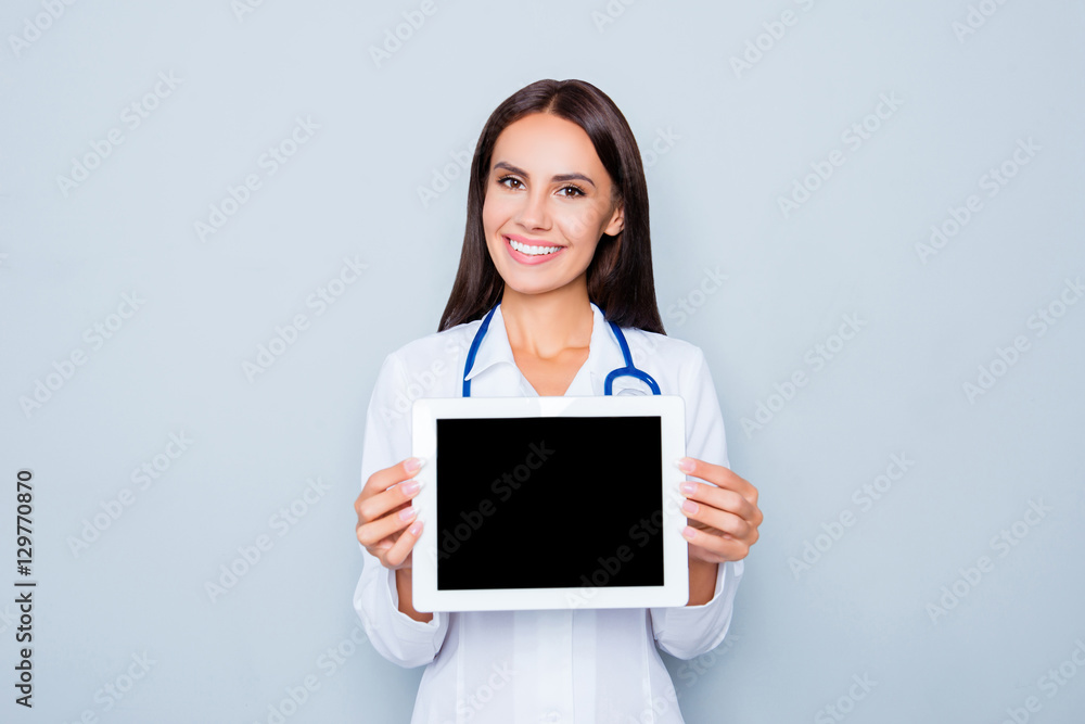 Wall mural Pretty smiling doctor showing black screen of tablet