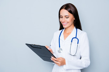 Young medical doctor writing diagnosis in her folder