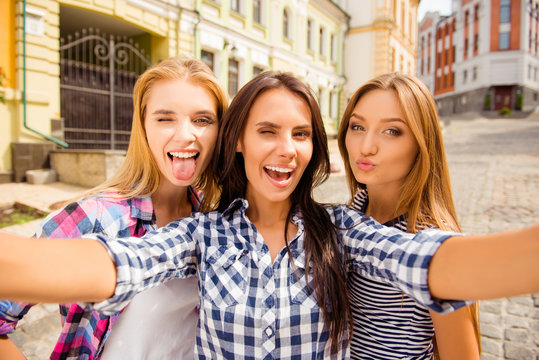 Funny selfie of three girlfriends pouting and showing tongue