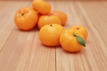 Mandarin Oranges with a small leaf on wooden background