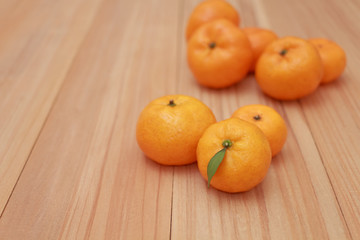 Mandarin Oranges with a small leaf on wooden background