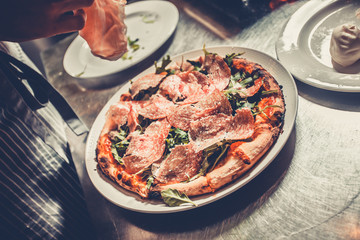 Chef cooking a gourmet tasty pizza close-up