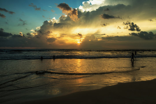 Beautiful sunset of Kuta Beach, Bali, Indonesia. Silhouettes of people at sunset on Kuta beach in Bali, Indonesia