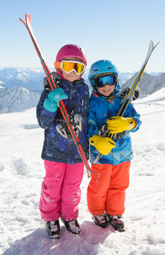 Smiling children  enjoying winter vacations in mountains . Ski,Sun, Snow and Fun.