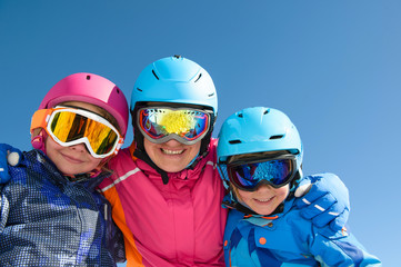 Happy family enjoying winter vacations in mountains . Ski, Sun,Snow and Fun
