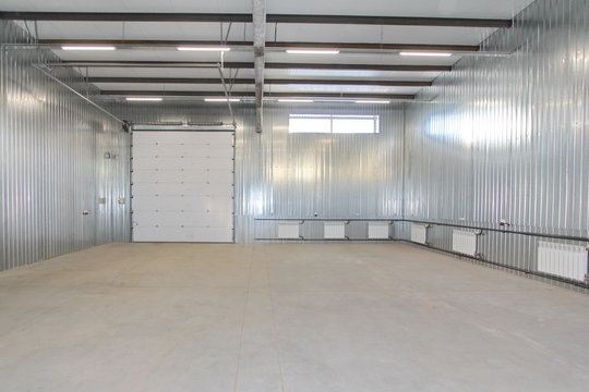 empty parking garage, warehouse interior with large white gates and windows inside