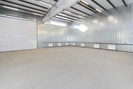 empty parking garage, warehouse interior with large white gates and windows inside