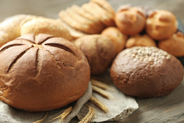 Fresh bread with spikes of wheat on a wooden table