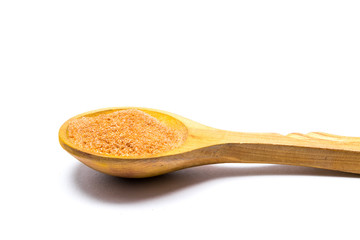 Orange food coloring powder  in wooden spoon isolated  on white background