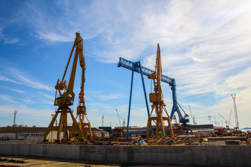 Fototapeta na wymiar Beautiful landscape of cranes in shipyard against a backlight in coast of Huelva, Andalusia, Spain.