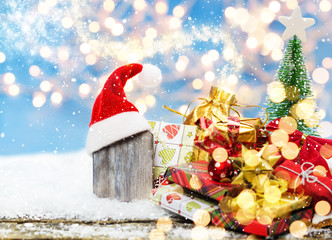 Holzschild mit Weihnachtsmütze an Weihnachtsgeschenken, Weihnachtseinkauf