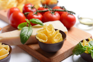 Pasta and tomatoes on wooden background