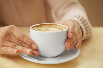 Woman holding cup of coffee, closeup