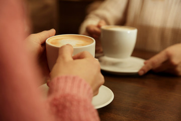 Female hands holding cup of coffee, closeup