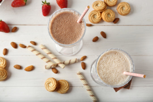 Tasty milk cocktails on wooden background