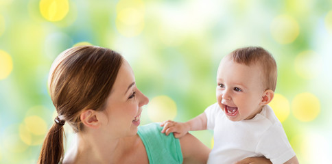 happy mother with little baby over green lights
